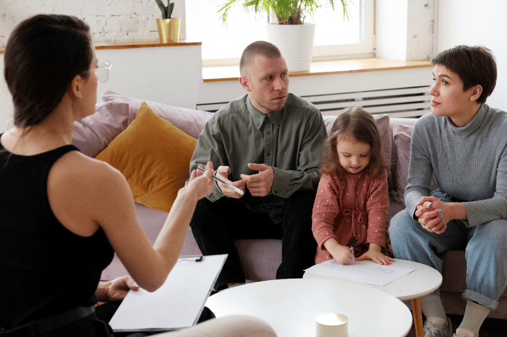 Parents and child meeting with a legal or counseling professional