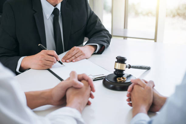 Attorney taking notes during a client consultation, gavel on the desk
